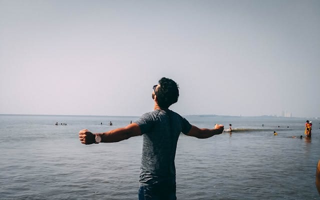 Persona con los brazos abiertos en actitud de liberación y alegría