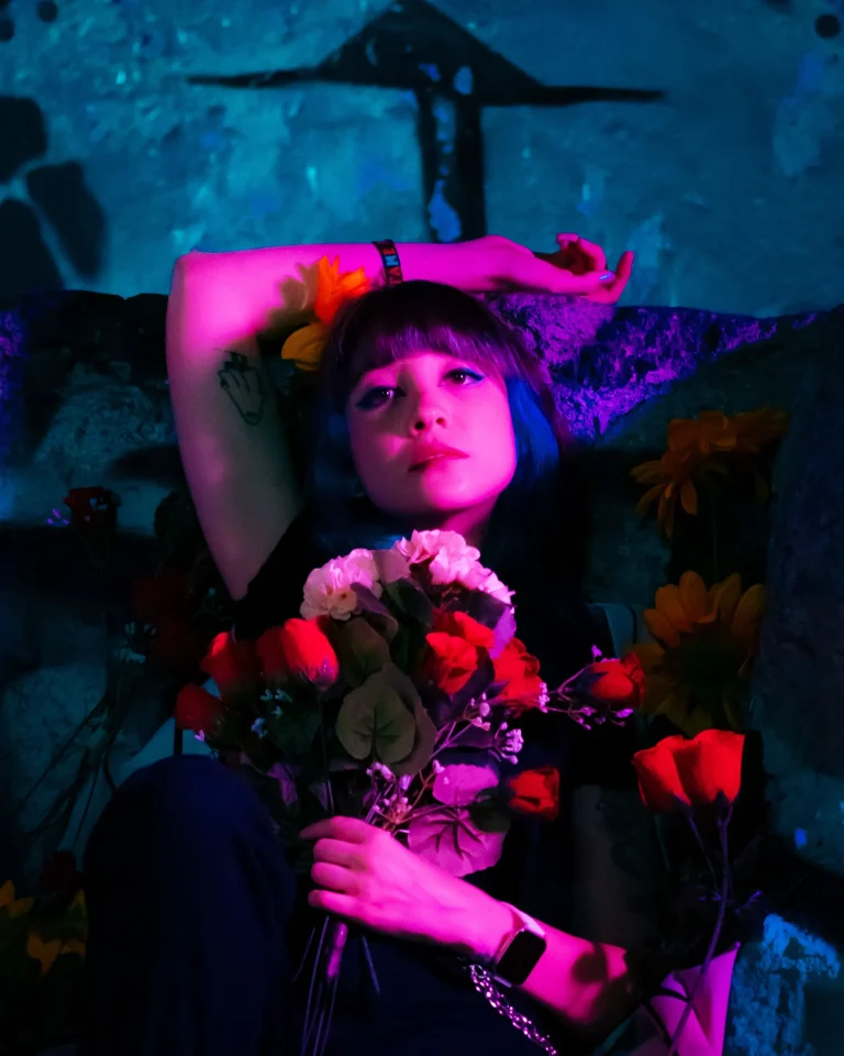 Mujer con gesto triste sujetando un ramo de flores tras una decepción amorosa en una relación marcada por dependencia emocional.